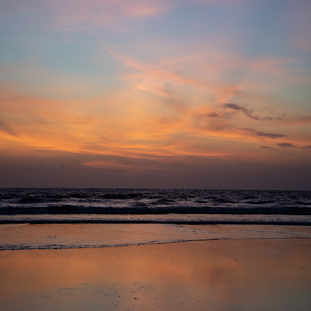 Sunset With The Waves Breaking On The Beach